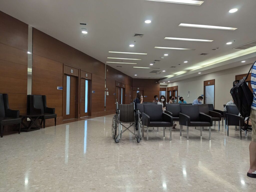 Interior view of a modern and spacious waiting area with chairs and a wheelchair in Bangkok Hospital Pattaya