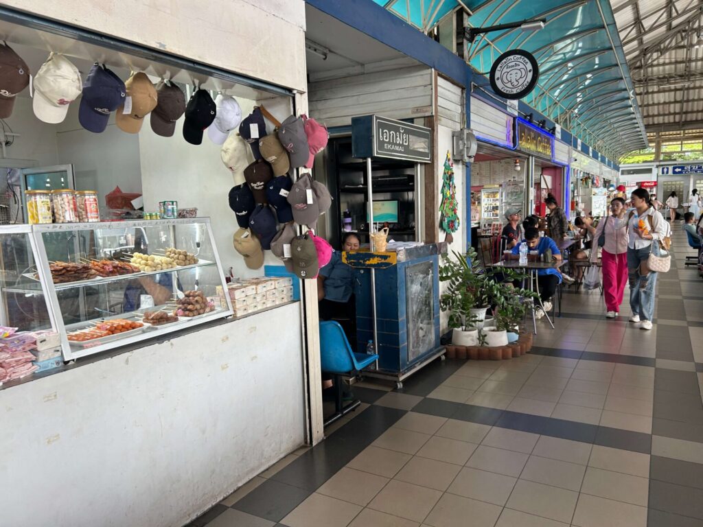 Local food stalls and seating area at North Pattaya Bus Terminal, with various Thai dishes