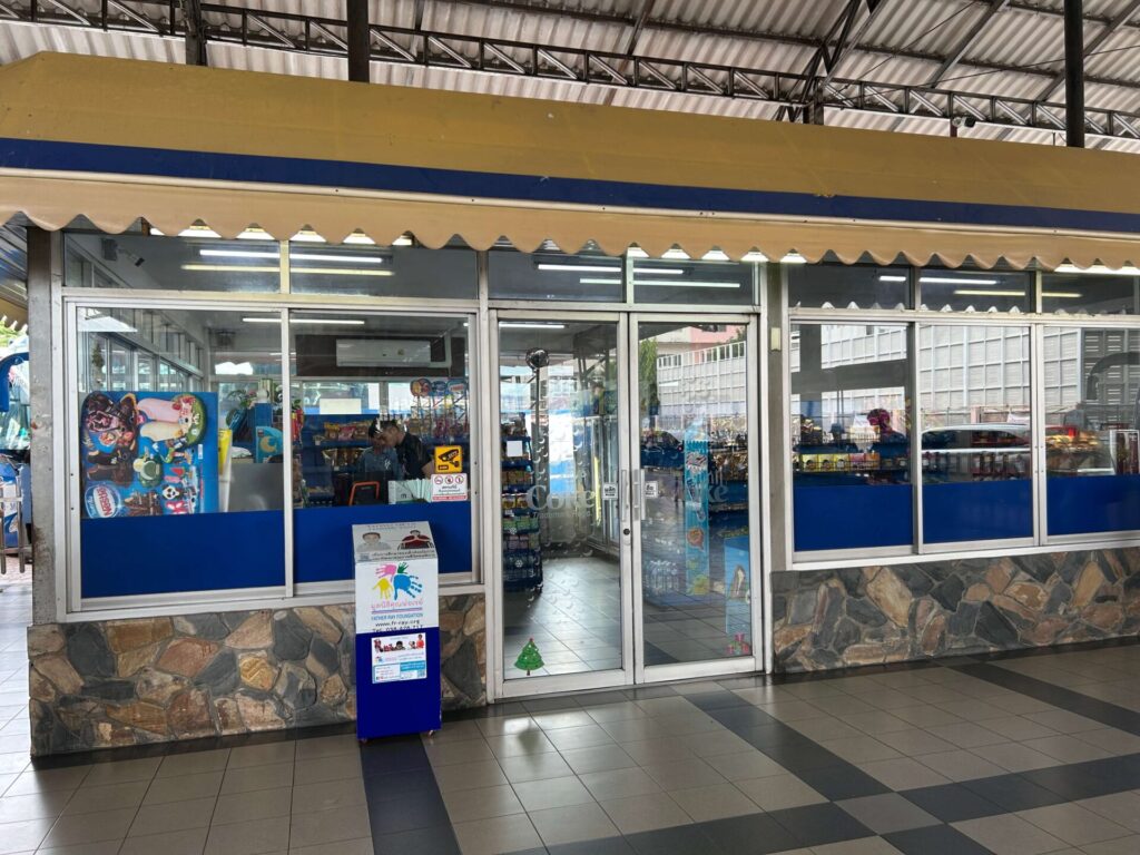 Exterior view of a convenience shop at North Pattaya Bus Terminal, selling snacks and drinks.