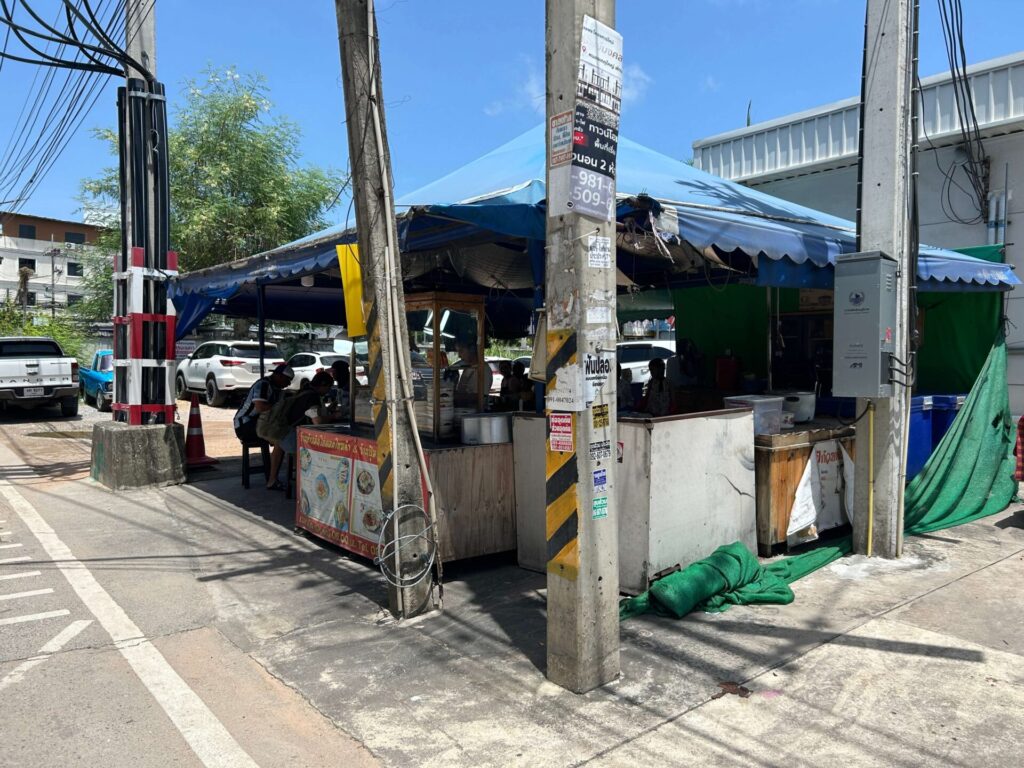 Exterior of a local duck noodle street food stall with a blue awning in North Pattaya