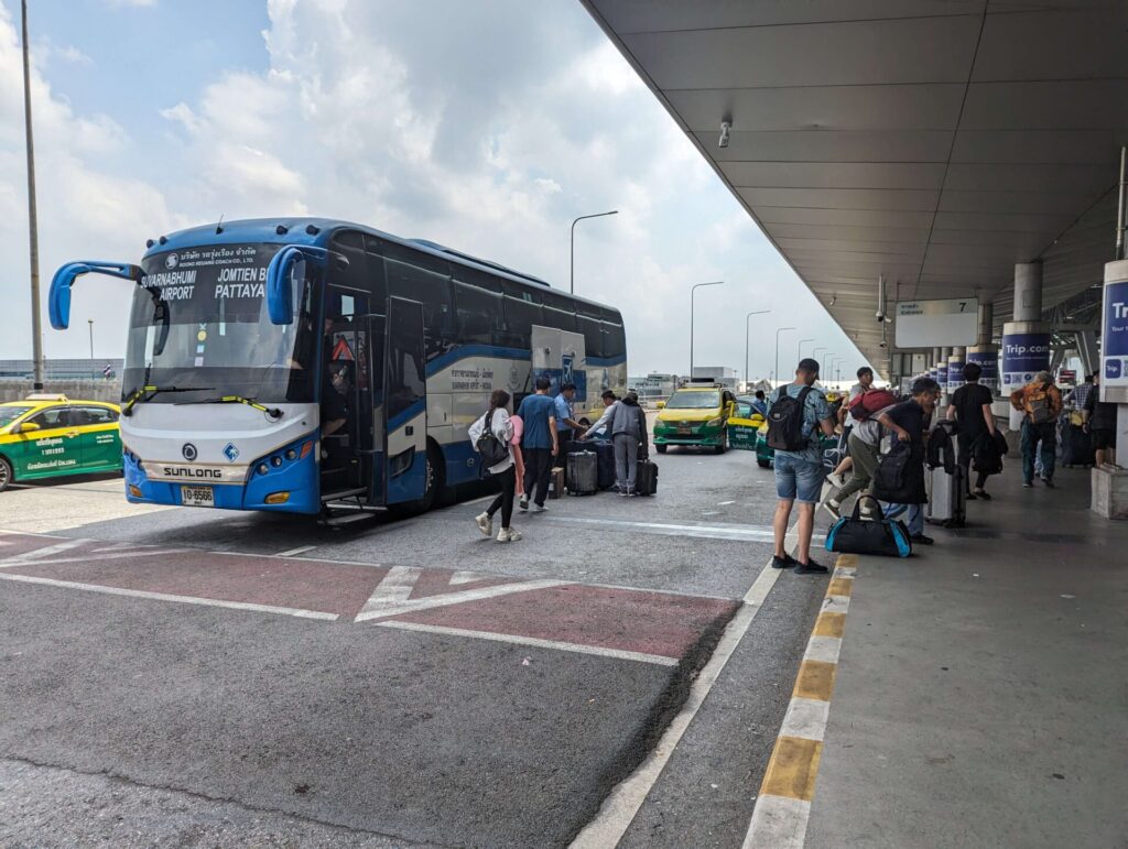 Passengers disembarking from a Roong Reuang Coach bus at the designated bus terminal at Suvarnabhumi Airport