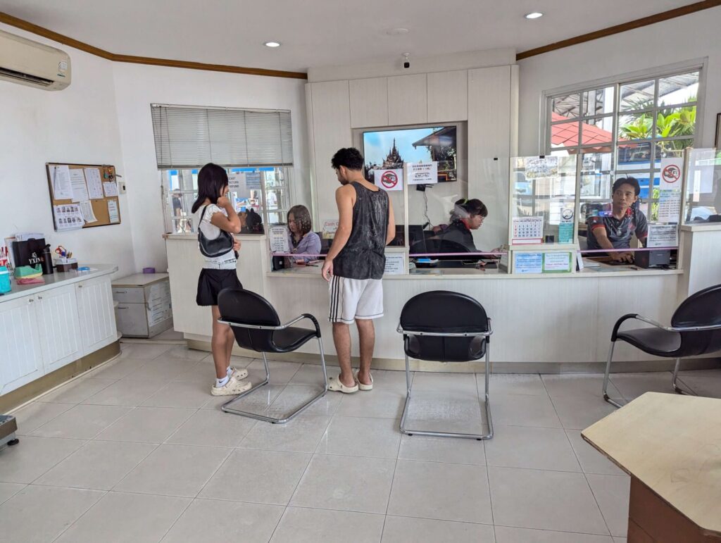 Interior view of the Bell Travel Service reception counter with staff assisting customers