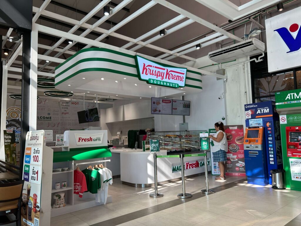 The brightly lit Krispy Kreme Doughnuts store at Little Walk Pattaya, featuring fresh doughnuts