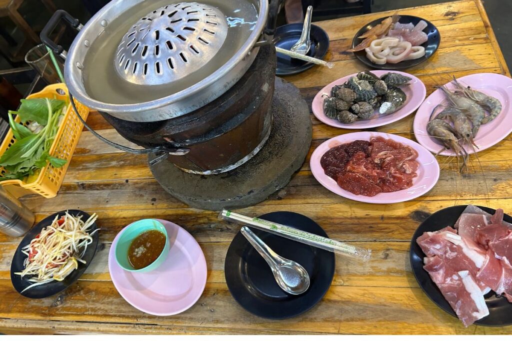Traditional Thai Mookata grill with fresh meats, seafood, and dipping sauce
