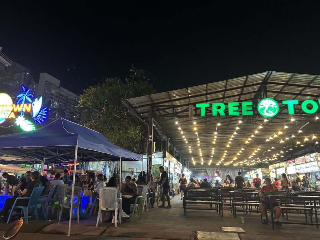 The vibrant night view of Soi Buakhao near Tree Town, featuring bright lights from the night market, street vendors, and a busy crowd.