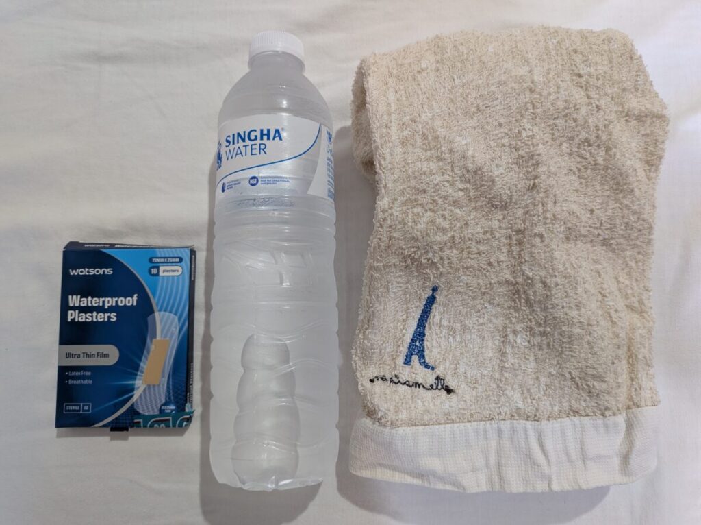 Essential items for a day trip to Koh Larn, including cash, water bottle, towel, and band-aids.
