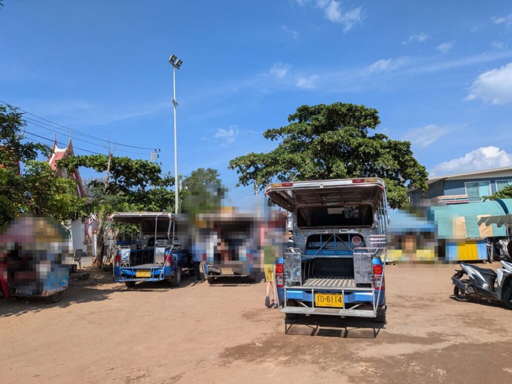 Songthaews waiting at Samae Beach road to take passengers directly to Na Baan Pier for the return ferry.