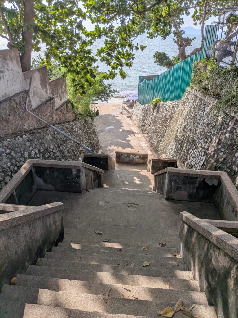 Steep concrete stairway leading down to Paradise Beach Pattaya through shaded trees