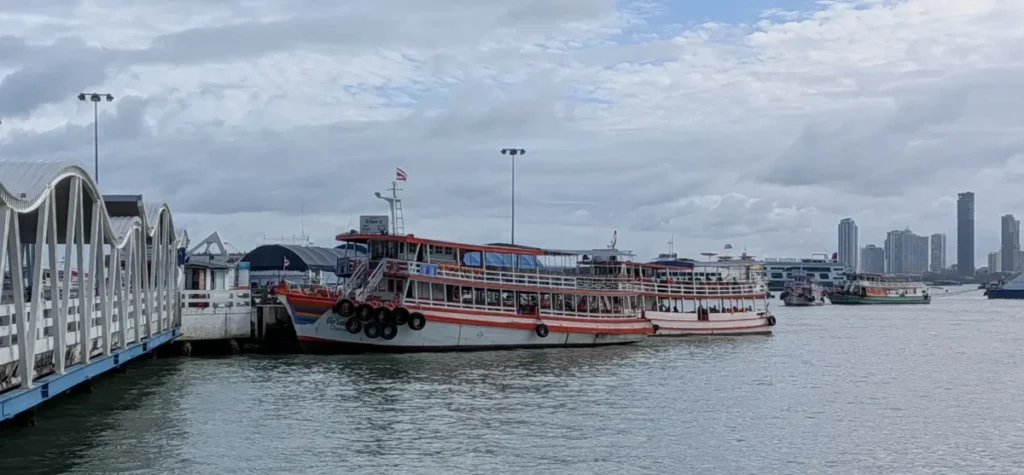 Classic wooden passenger ferries docked at Bali Hai Pier with the Pattaya skyline in the background.
