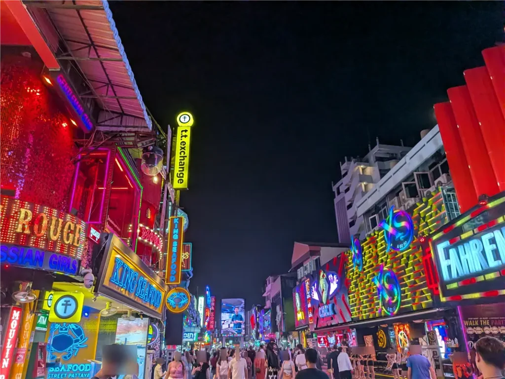 Bright neon signs of Go-Go bars and nightclubs crowded with tourists on Walking Street in Pattaya.
