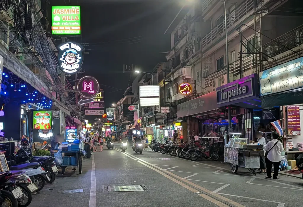 Soi Buakhao at night with bars, motorbikes, and limited sidewalk space