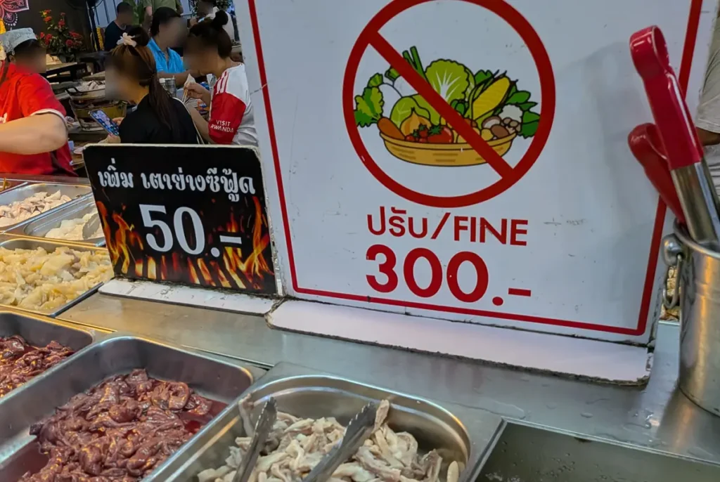 Mookata buffet with large food trays and smaller plates for different ingredients in Pattaya
